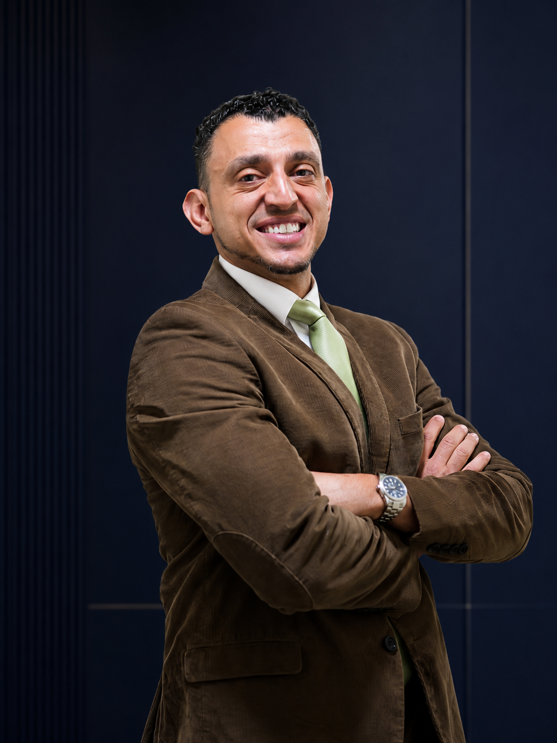 Ibrahim J. Awad, arms folded, in a studio portrait